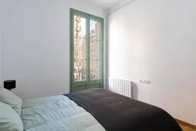 a bedroom with a bed with a green window at Modernist Family Apartment by PriorityVillas in Barcelona