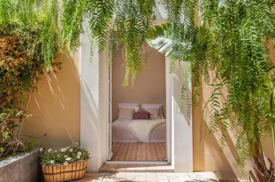 a bedroom with a bed in a courtyard with plants at Casa Nova Estate in Sitges