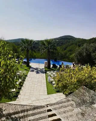 a walkway with tables and chairs next to a body of water at Casa Nova Estate in Sitges