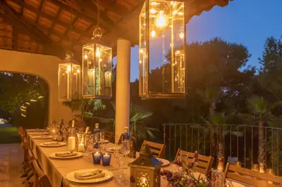 a long table with plates and candles and lights at Casa Nova Estate in Sitges