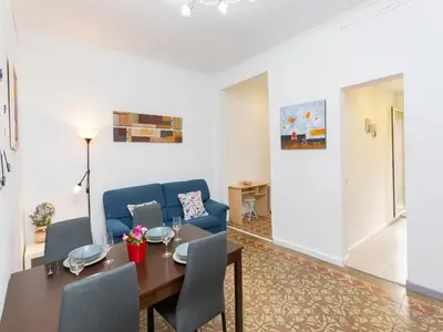 a living room with a table and a blue couch at Apartment Gracia- Providencia by Interhome in Barcelona