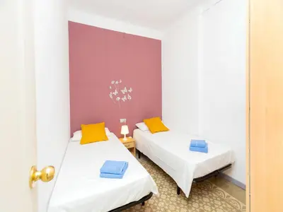 two beds in a small room with a door at Apartment Gracia- Providencia by Interhome in Barcelona
