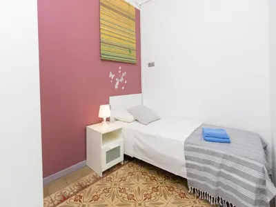 a small bedroom with a bed and a night stand at Apartment Gracia- Providencia by Interhome in Barcelona