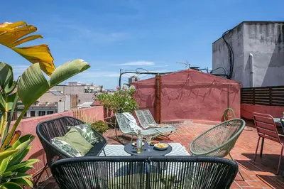 a patio with a table and chairs on a balcony at Glam Penthouse Barcelona in Barcelona