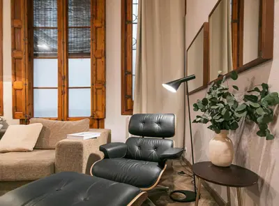 a living room with a leather chair and a couch at Avinyo 2 Gotic · Spacious Loft in Gothic Quarter! in Barcelona