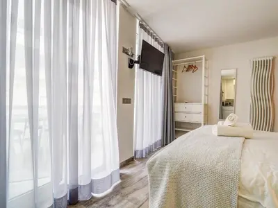 a bedroom with a bed and a large window at Blue Serenity by Hello Homes Sitges in Sitges