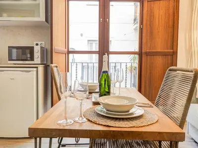 a wooden table with glasses and a bottle of wine at The Green Oasis by Hello Homes Sitges in Sitges