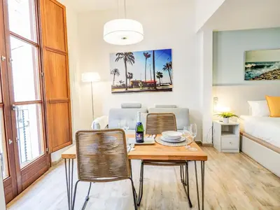 a living room with a table and chairs and a bed at The Green Oasis by Hello Homes Sitges in Sitges