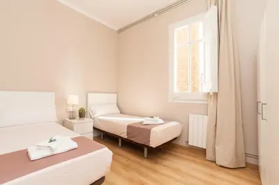 a bedroom with two beds and a window at Housalia Sagrada Familia in Barcelona