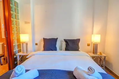 a bedroom with a large bed with blue towels on it at La Marina Sea Front by Hello Homes Sitges in Sitges