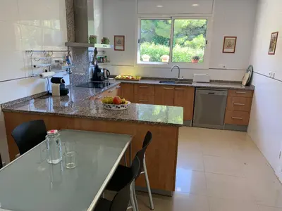 a kitchen with a counter and a table with chairs at Villa Dacar in Cubelles