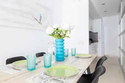 a dining room table with a blue vase with white flowers at vilasardemarlux3 in Vilassar de Mar
