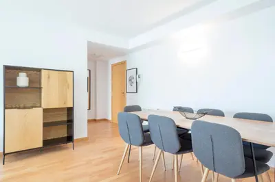 a dining room with a table and blue chairs at Alcam Rubi in Rubí