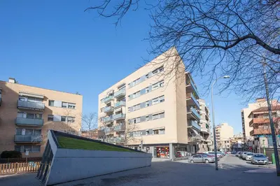 a tall building in a city with cars parked in front of it at Alcam Rubi in Rubí