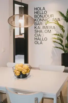 a white dining room table with a bowl of fruit on it at BBarcelona Central Boutique Apartments in Barcelona