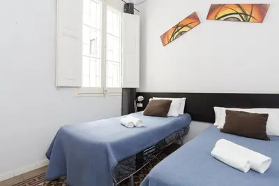 a room with two beds with blue sheets and a window at Key Plaza Universidad - Gran Via in Barcelona