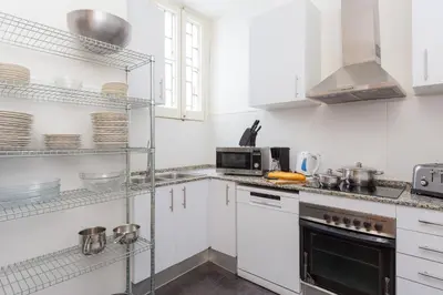 a white kitchen with white cabinets and a microwave at Key Plaza Universidad - Gran Via in Barcelona