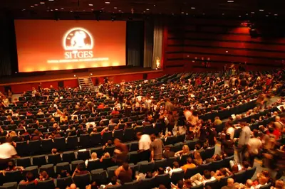 a crowd of people in an auditorium with a screen at Vinyet Sitges in Sitges