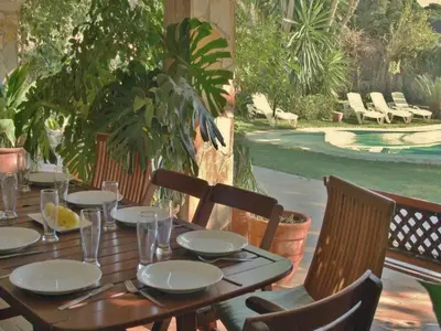 a wooden table with plates and glasses on a patio at Villa in Sant Pol near Crystal Beach in San Pol de Mar