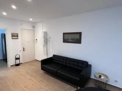 a living room with a black couch and a white wall at VIU BARCELONA BERTRAN in Barcelona