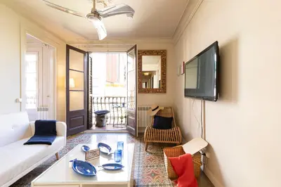 a living room with a white couch and a tv at Urban Apartments in Barcelona