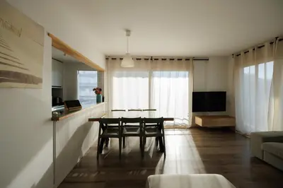 a dining room with a table and chairs in a room at Gran Apartmento Playa Badalona in Badalona