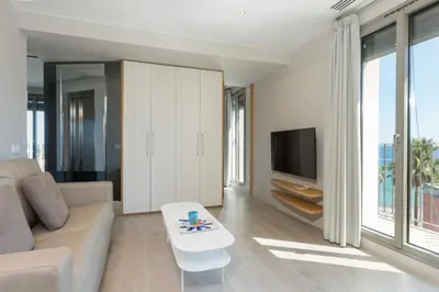 a living room with a couch and a tv at Kronos on the Beach Attic Suite in Barcelona
