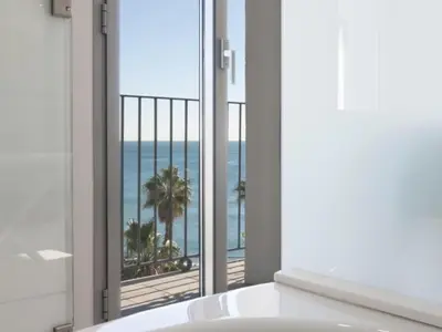 a bathroom with a tub and a view of the ocean at Kronos on the Beach Attic Suite in Barcelona
