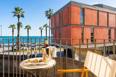 a table on a balcony with a view of the ocean at Kronos on the Beach suite 1 in Barcelona