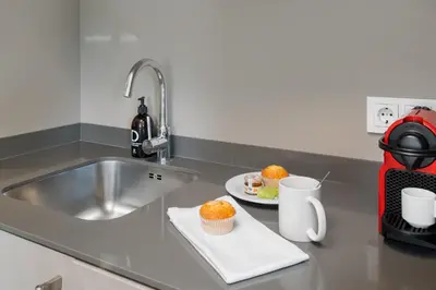 a kitchen counter with a sink and a plate of cupcakes at Kronos on the Beach suite 1 in Barcelona