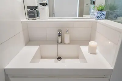 a white sink in a bathroom with a mirror at Kronos on the Beach suite 3 in Barcelona
