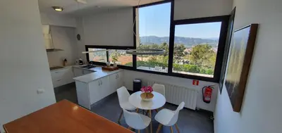a kitchen with a table and chairs and windows at Villa Vicente in Canyelles