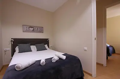 a bedroom with a large bed with towels on it at MUNNE - Spacious apartments next to FC Barcelona in Barcelona