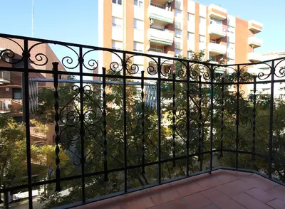a balcony with a black fence and a building at MUNNE - Spacious apartments next to FC Barcelona in Barcelona