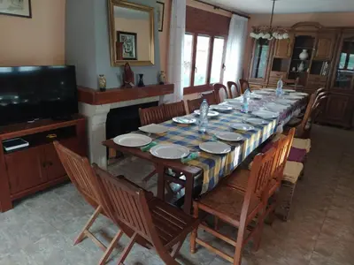 a dining room with a long table and chairs at Casa en Parque Natural del Montseny. in Santa María de Palautordera