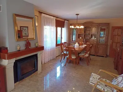 a dining room with a table and a fireplace at Casa en Parque Natural del Montseny. in Santa María de Palautordera