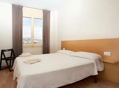 a white bedroom with two beds and a window at RIUS - Apartments & one Penthouse with private terrace in Montjuic in Barcelona