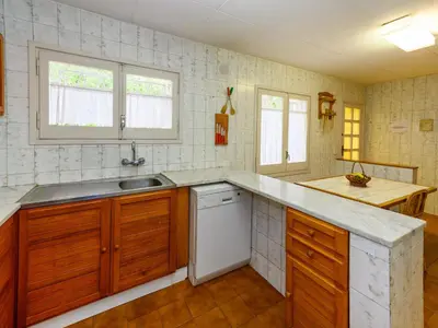 a kitchen with wooden cabinets and a white dishwasher at Holiday Home La Marina Blanca by Interhome in San Pol de Mar