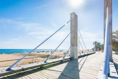 a bridge over a boardwalk at the beach at HomeHolidaysRentals Moana in Calella