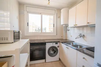 a kitchen with a washing machine and a sink at HomeHolidaysRentals Moana in Calella