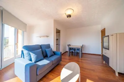a living room with a blue couch and a table at HomeHolidaysRentals Elodie in Calella