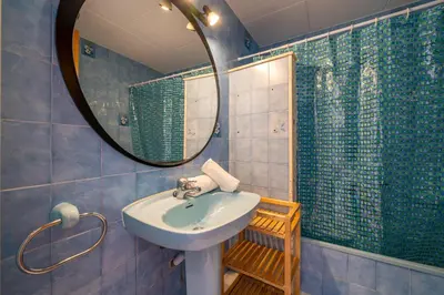 a bathroom with a sink and a mirror and a shower at HomeHolidaysRentals Elodie in Calella