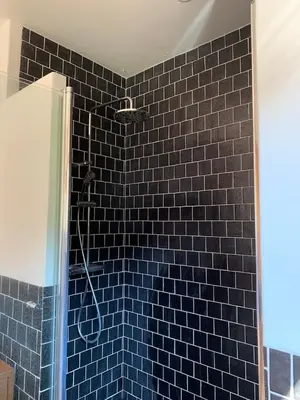 a blue tiled bathroom with a shower with a blue tile wall at Cal Secretari in Rellinars