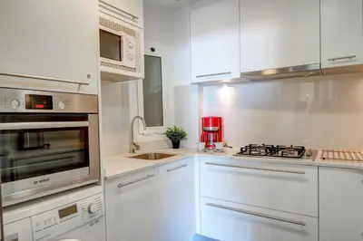 a kitchen with white cabinets and a stove top oven at La Gioia 1 by Hello Homes Sitges in Sitges