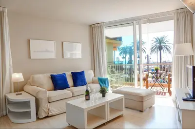 a living room with a couch and a large window at La Gioia 1 by Hello Homes Sitges in Sitges