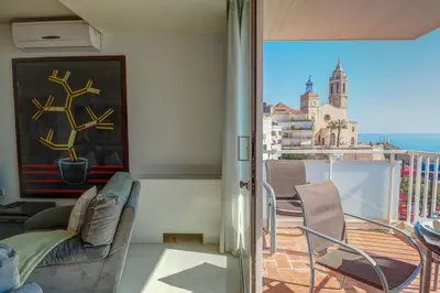a room with a balcony with a view of the city at La Gioia 2 by Hello Homes Sitges in Sitges