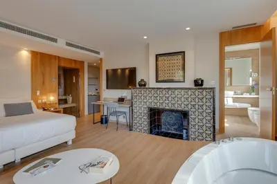 a living room with a bed and a fireplace at Hotel Boutique Mirlo Barcelona in Barcelona