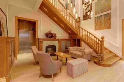a living room with a staircase and a fireplace at Hotel Boutique Mirlo Barcelona in Barcelona