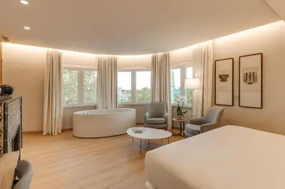 a bedroom with a bed and a tub in a room at Hotel Boutique Mirlo Barcelona in Barcelona