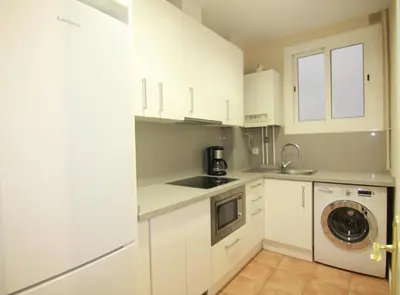 a kitchen with white cabinets and a washing machine at CORSEGA - Apartment in the center of Barcelona in Barcelona